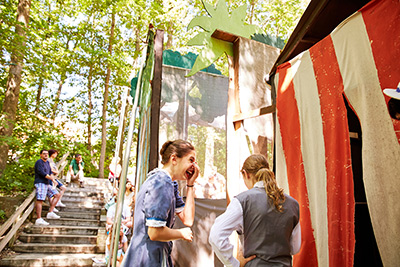 Young theater campers in costume smiling backstage