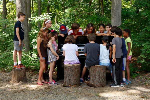 Usdan student performs for a surrounding group of kids