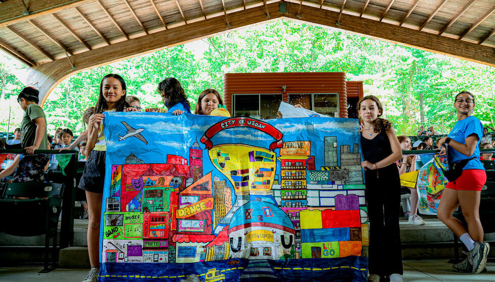 Students standing with City of Usdan artwork