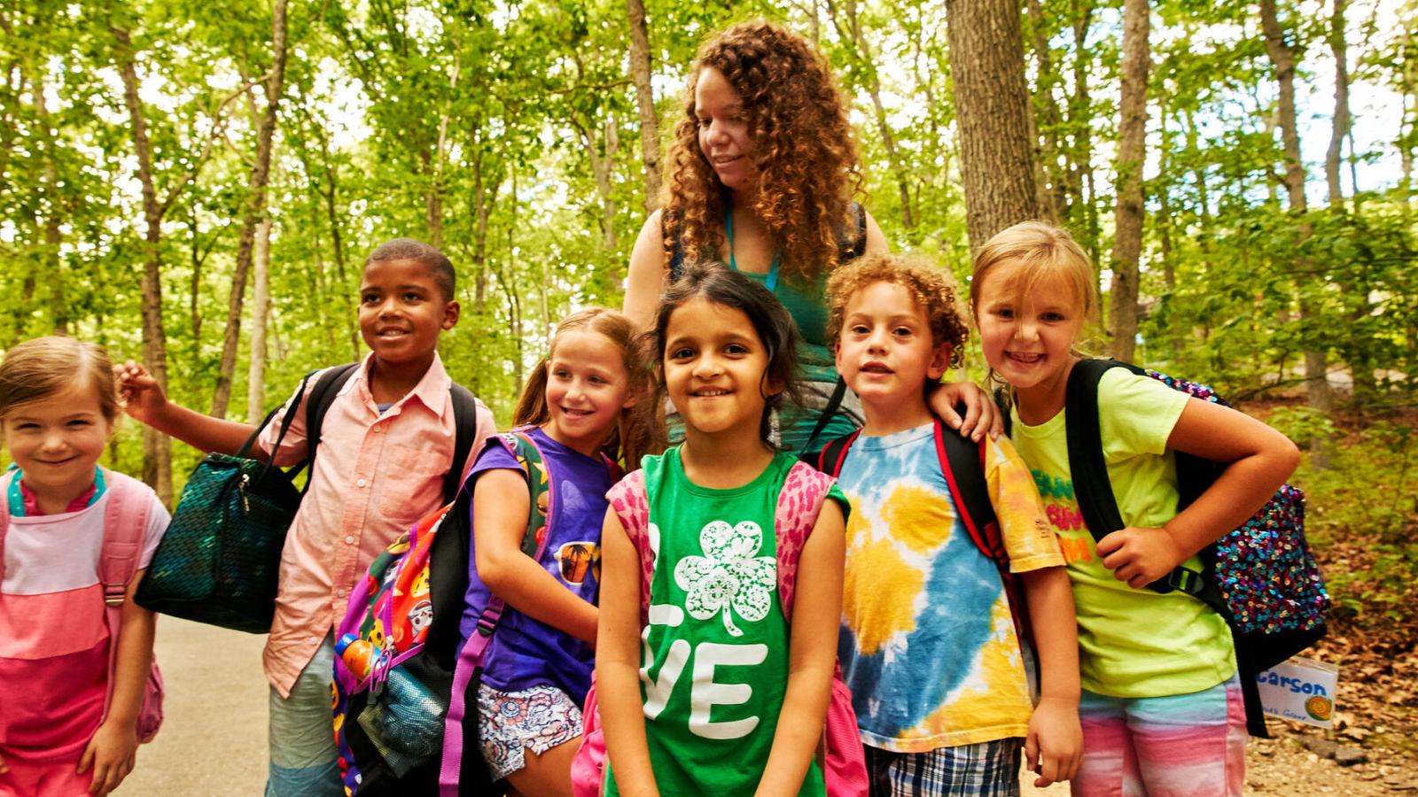 Group of children standing in the woods smiling