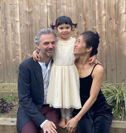 Colin, Mimi, and Maile posing in front of a wooden fence 