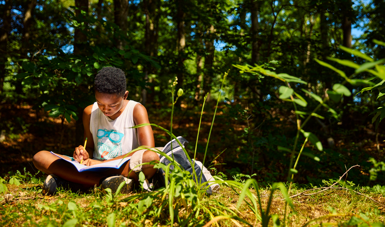 Student writing camp in the woods of Long island
