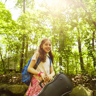 Girl in the woods holding a violin. 