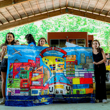 Students standing with City of Usdan artwork