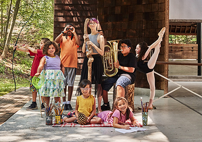 Campers posing with props representing each department